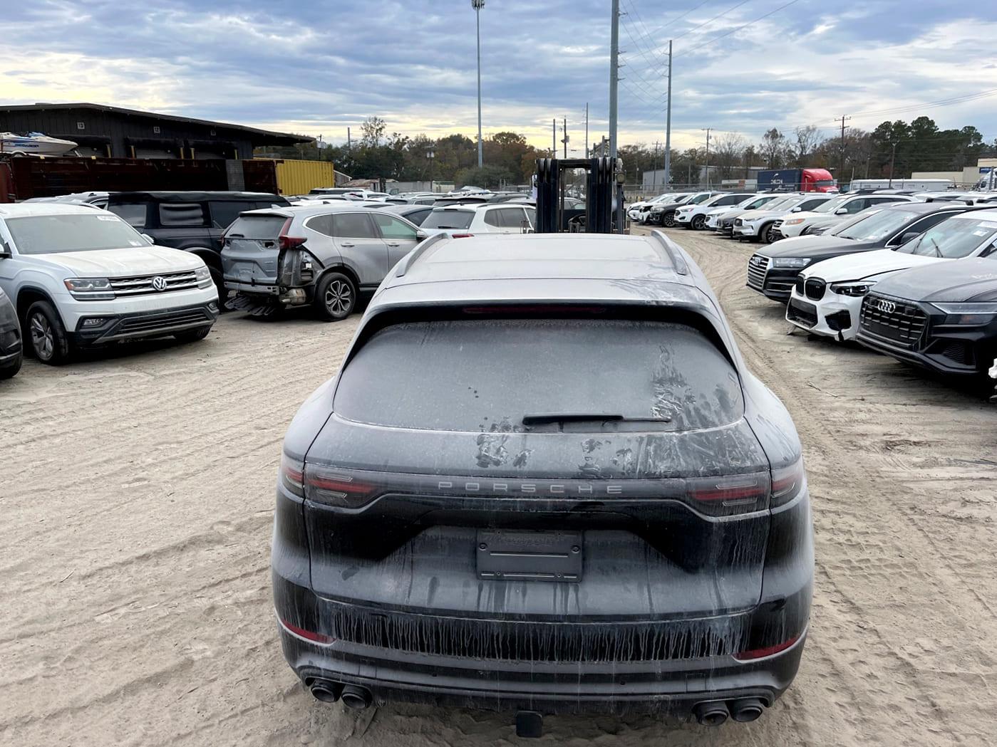 Porsche Cayenne noir parmi les voitures d'enchères sur un parc