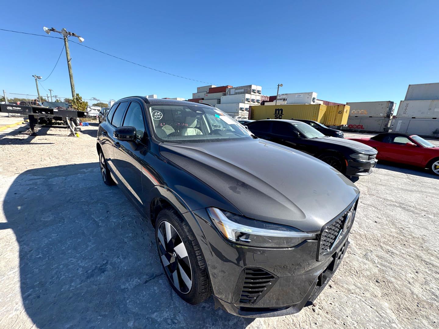 Volvo XC60 gris dans un terminal portuaire près des conteneurs